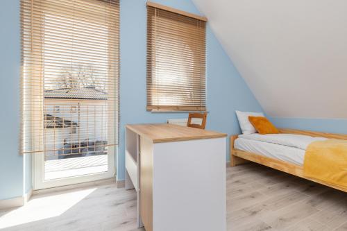 a bedroom with blue walls and a bed and a window at Comfy Studio Zamkowa 400m from the Beach by Renters in Puck