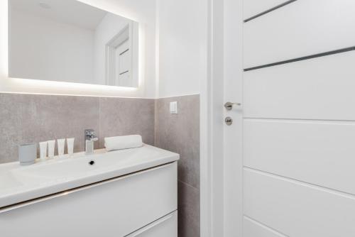 a bathroom with a white sink and a mirror at Comfy Studio Zamkowa 400m from the Beach by Renters in Puck