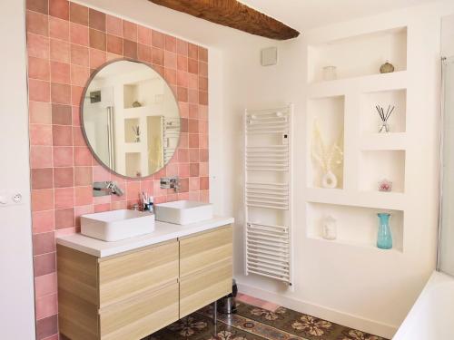 uma casa de banho com 2 lavatórios e um espelho em La Casa Rosa em Opoul-Périllos