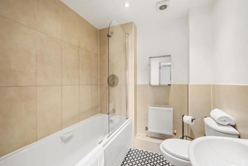 a bathroom with a tub and a toilet and a sink at Luxnightzz - Two Bed - Close to North Station and Hospital in Colchester