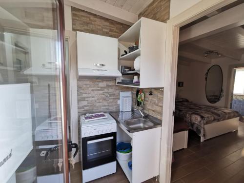 una piccola cucina con lavello e fornello di Appartamenti Camerota a Camerota