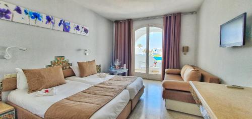 una camera d'albergo con letto e divano di Zenon Djerba a Midoun