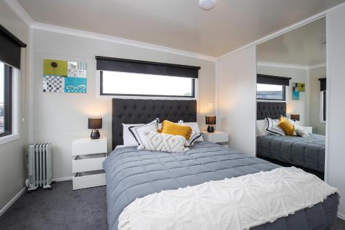 - une chambre avec 2 lits et un grand miroir dans l'établissement Affordable Modern Accommodation, à Westport