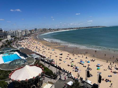 een strand met veel mensen en de oceaan bij Centre Maison appartement 100 m de la plage 150 m du port in Les Sables-dʼOlonne