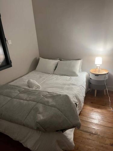 - un lit dans une chambre avec une lampe sur une table dans l'établissement Plein Centre Maison appartement 100 m de la plage 150 m du port, à Les Sables-dʼOlonne