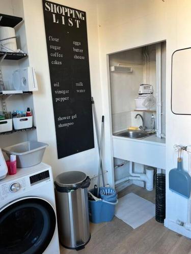une cuisine avec un évier et une machine à laver dans l'établissement Plein Centre Maison appartement 100 m de la plage 150 m du port, à Les Sables-dʼOlonne