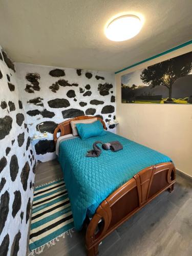 ein Schlafzimmer mit einem Bett mit einer Kuhdruckwand in der Unterkunft Los Amantes de la naturaleza. in Salão