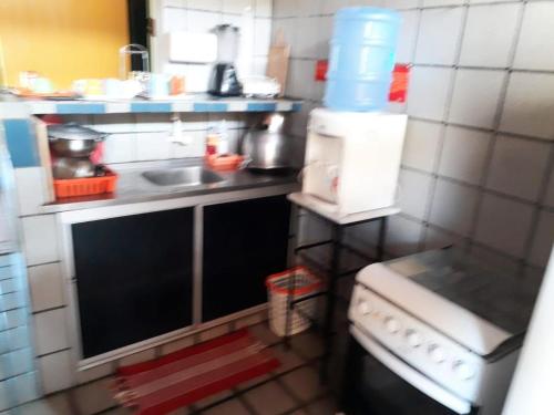 uma pequena cozinha com um lavatório e um fogão em Flat260 Beira Mangue Mar ar piscinas estac zelador em Itamaracá