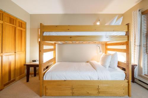 1 Schlafzimmer mit 2 Etagenbetten und einem Schreibtisch in der Unterkunft Forest Trails by Outpost Whistler in Whistler