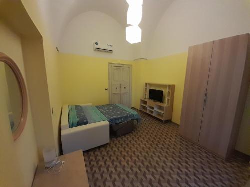 ein kleines Schlafzimmer mit einem Bett und einem TV in der Unterkunft Sweet Home in Leverano