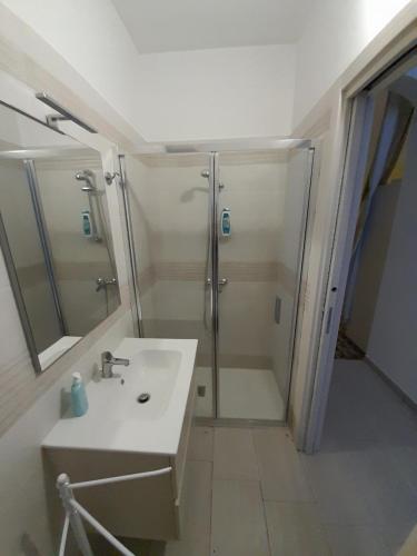 ein Bad mit einer Dusche und einem weißen Waschbecken in der Unterkunft Sweet Home in Leverano