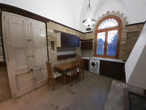 a kitchen with a table and chairs and a window at Sweet Home in Leverano