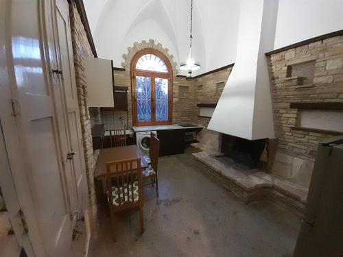 a room with a stone fireplace and a table and chairs at Sweet Home in Leverano