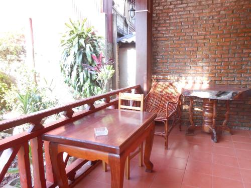 a wooden table and chairs on a balcony at Zuela Guesthouse in Louang Namtha