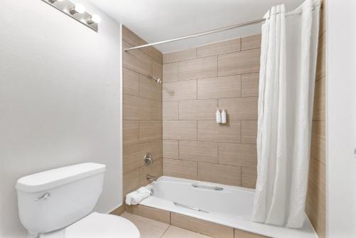 a bathroom with a tub and a toilet and a shower at Heritage Inn Express Roseville in Roseville
