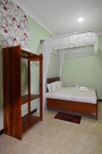 ein Schlafzimmer mit einem Himmelbett in der Unterkunft BETTER LIFE HOTEL KASULU 