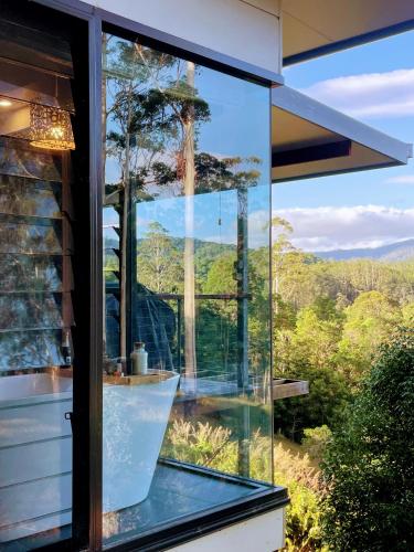 a glass room with a view of the mountains at La Rochér Eco Retreat in Stokers Siding