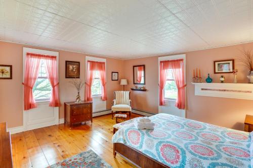a bedroom with a bed and windows with red curtains at Stamford Farmhouse with Deck in Catskill Foothills in Stamford