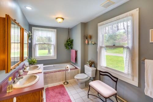 a bathroom with two sinks and a tub and a toilet at Stamford Farmhouse with Deck in Catskill Foothills in Stamford