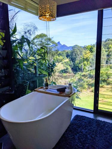 a bath tub in a room with a large window at La Rochér Eco Retreat in Stokers Siding
