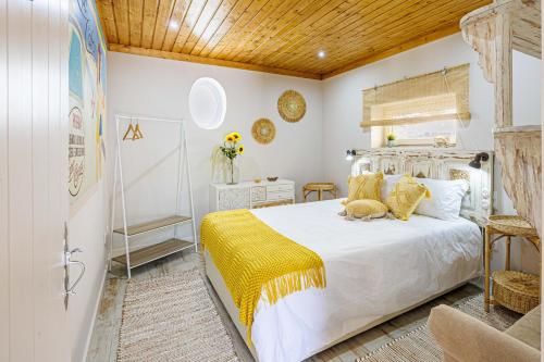 um quarto com uma cama grande e um cobertor amarelo em Casas Du Rio em Maceira