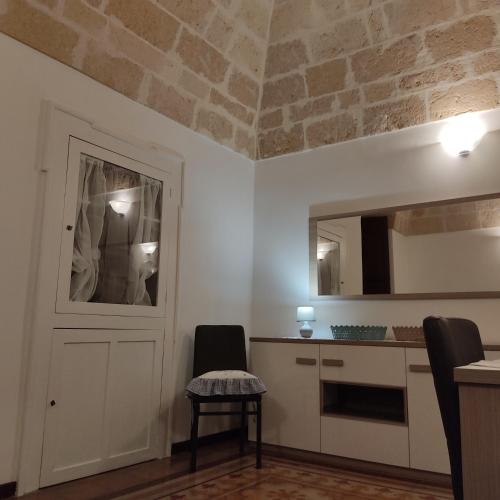 a kitchen with a table and two chairs and a door at DIMORA STORICA ALLA ROTONDA in Mottola