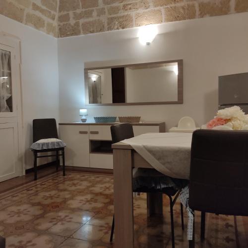 a room with a table and chairs and a kitchen at DIMORA STORICA ALLA ROTONDA in Mottola