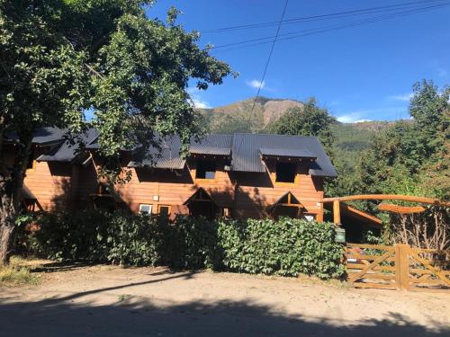 una casa de madera con una valla delante en Cabañas Ojo de Cielo en San Carlos de Bariloche