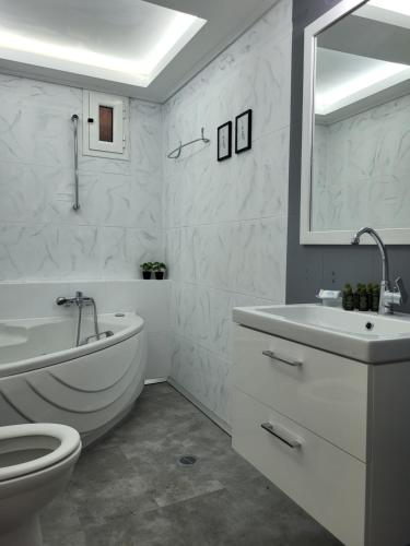 baño blanco con bañera, aseo y lavamanos en Rêve, en Zakynthos