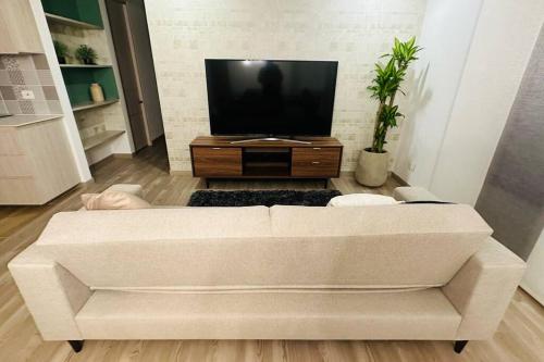 ein weißes Sofa im Wohnzimmer mit einem TV in der Unterkunft Brand new Apt, perfect City view in Bogotá