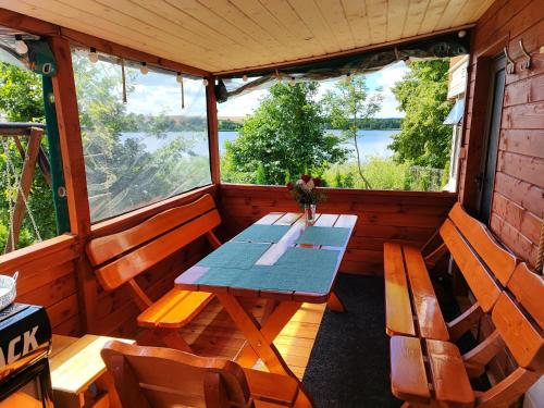 a dining room with a table and chairs in a cabin at Siedlisko nr 3 nad jeziorem Skarlińskim, domki letniskowe, mazury, jezioro,bania in Nowe Miasto Lubawskie