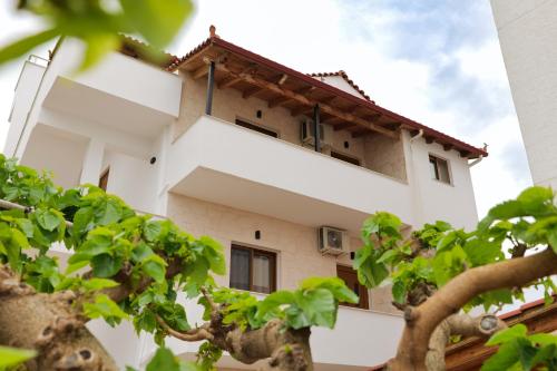 a white building with trees in front of it at Villa Abedini in Ksamil
