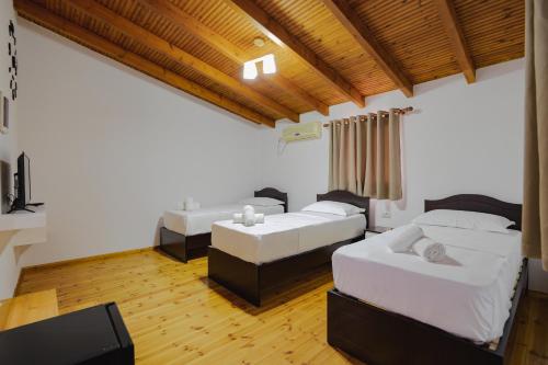 a living room with two beds and a couch at Villa Abedini in Ksamil