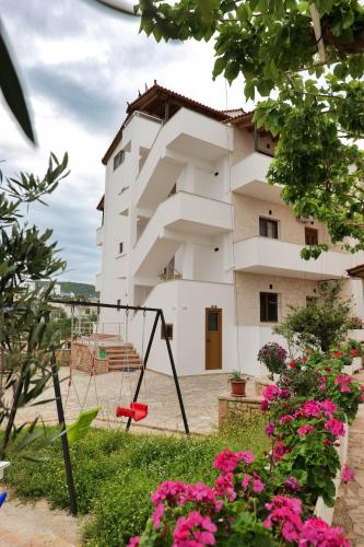 a apartment building with a swing in front of it at Villa Abedini in Ksamil