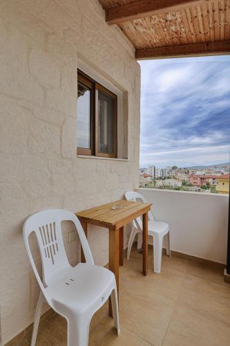 a table and chairs on a balcony with a view at Villa Abedini in Ksamil
