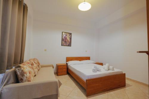 a small bedroom with a bed and a couch at Villa Abedini in Ksamil
