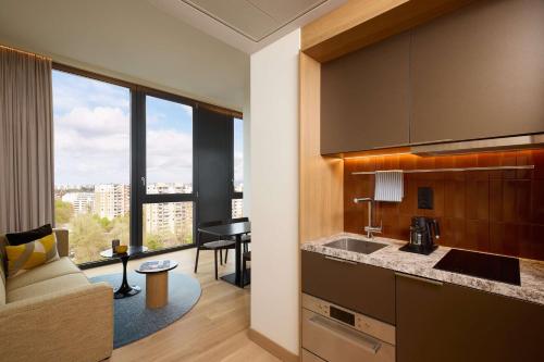 a kitchen and living room with a couch and a table at Adina Apartment Hotel Geneva in Geneva