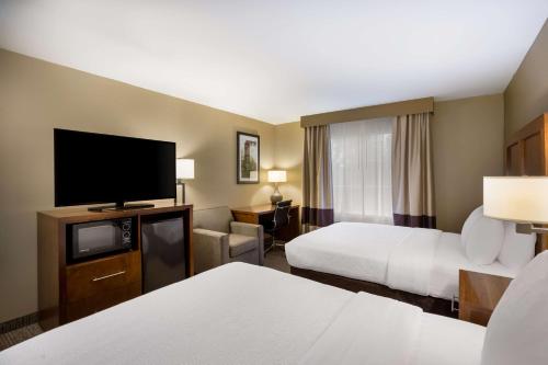 a hotel room with two beds and a flat screen tv at Best Western Morgan City Inn in Morgan City