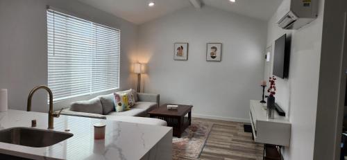 a white living room with a couch and a table at Luxury family-friendly 2BR Home near downtown SD in National City