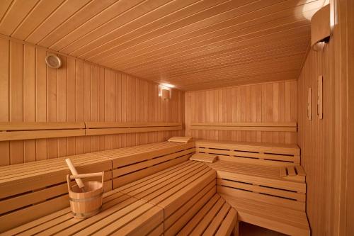 a wooden sauna with benches and a trash can at Adina Apartment Hotel Geneva in Geneva