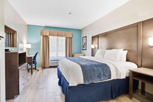 Habitación de hotel con cama y escritorio en Blue Water Inn & Suites BW Signature Collection en North Topsail Beach