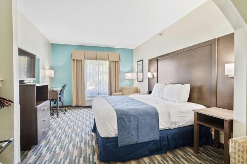 a hotel room with a large bed and a desk at Blue Water Inn & Suites BW Signature Collection in North Topsail Beach