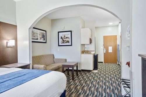 a hotel room with a bed and a kitchen at Blue Water Inn & Suites BW Signature Collection in North Topsail Beach