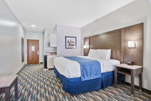 a hotel room with a large bed and a table at Blue Water Inn & Suites BW Signature Collection in North Topsail Beach