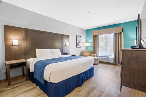 a hotel room with a large bed and a television at Blue Water Inn & Suites BW Signature Collection in North Topsail Beach
