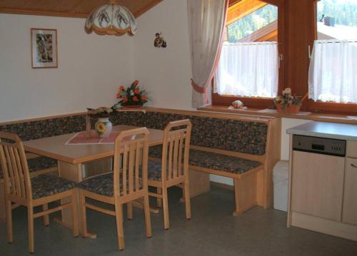 cocina con mesa, sillas y barra en Ferienwohnung Mützengruß, en Filzmoos