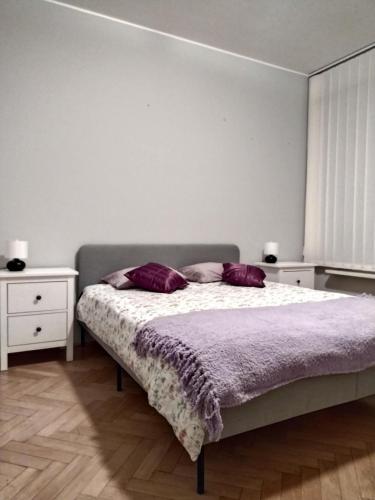a bedroom with a bed with two purple pillows at ToTuToTam in Warsaw