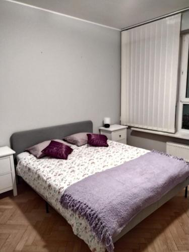 1 dormitorio con 1 cama grande con almohadas moradas en ToTuToTam, en Varsovia