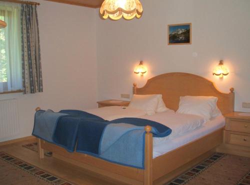 a bedroom with a bed with a blue blanket on it at Ferienwohnung Mützengruß in Filzmoos