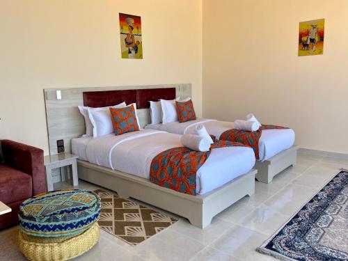 a bedroom with two beds and a chair at PARAISO DAKHLA in Dakhla